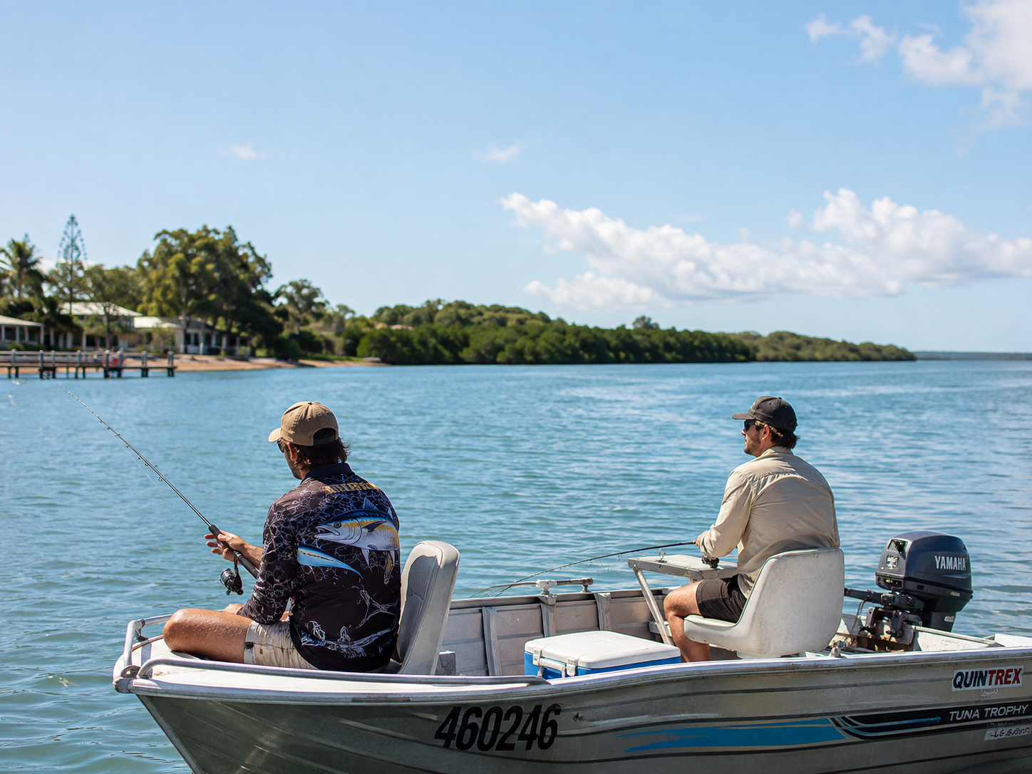 Two people fishing from a boat on the bay